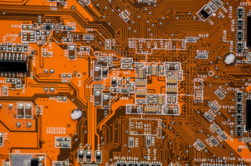 orange electronics computer part chip with many electrical components