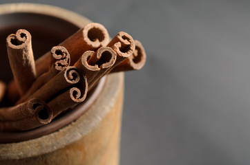 Food Background of Cinnamon Sticks, Spice Cinnamon Quills are stacked in an wooden mortar. Top...