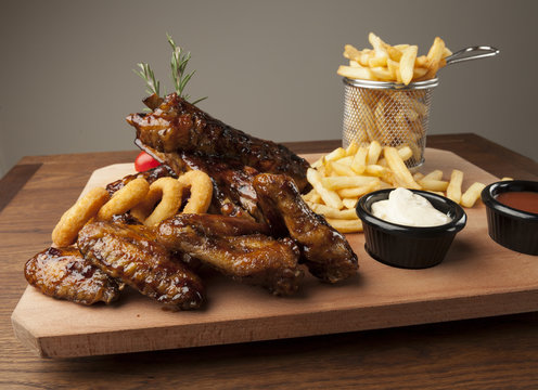 Meal Of Chicken Wings And Ribs With Fries