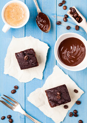 Brownie Schokoladenkuchen Stücke frisch gebacken auf türkisem Holz Tisch Hintergrund mit Kaffeetasse 