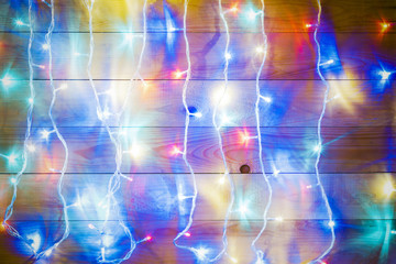 Christmas lights over old wooden background.