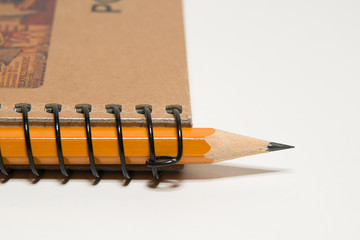 Closed notebook  and pencil on over white
