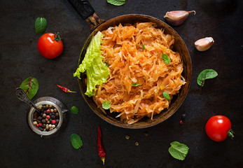 Stewed cabbage on the old wooden background in rustic style. Top view