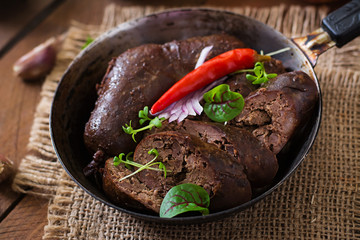 Homemade blood sausage with offal on the old wooden background in rustic style