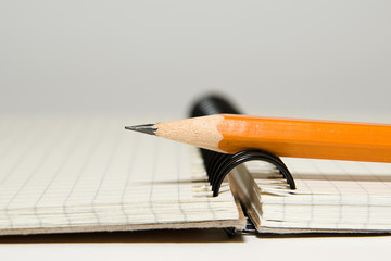 Opened notebook  and pencil on over white