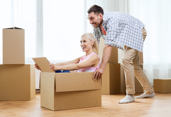 couple with cardboard boxes having fun at new home