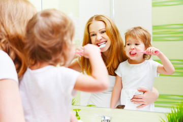mother and daughter child girl brushing her teeth toothbrushes f