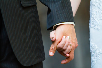 Obraz premium Bride and Groom Holding Hands on Wedding Day