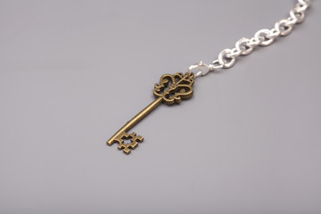 Fototapeta na wymiar Vintage Key with chain on gray background