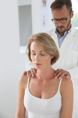 Chiropractor checking woman's spine