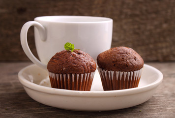 chocolate cupcakes with a cup of tea on a white plate