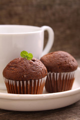 chocolate cupcakes with a cup of tea on a white plate