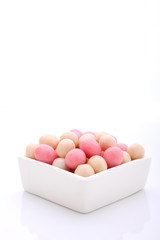 Fototapeta premium pink and white candy in a round white plate on a white background