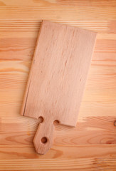 light wooden cutting board on a wooden background