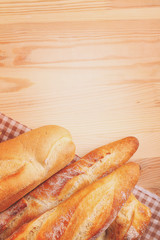 Freshly baked baguette and bread on wooden background