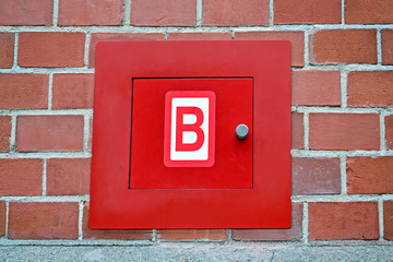 red fire box for hydrant, red brick wall, modern security