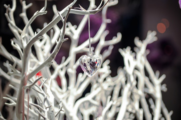 Christmas-tree decoration the glass heart hanging on white branch