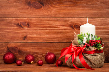 Christmas decoration - christmas composition with bag, white candle and balls on the wooden background.