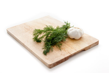 Dill and garlic on a wooden board