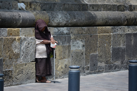 Señora pide dinero en una calle del centro de la ciudad.