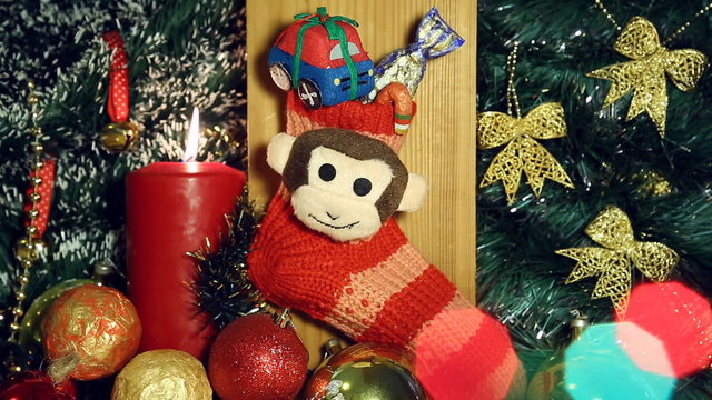 Red candle lights and red christmas sock with monkey next year symbol like a christmas background.