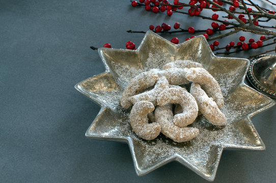 German Kipferl Cookies dusted with icing sugar on a star shaped plate against a grey background 1
