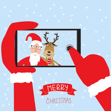 Hipster santa claus and reindeer selfie with smartphone for merr