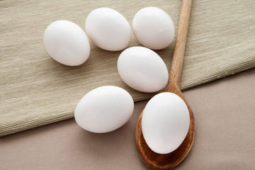 Fresh eggs on a wooden spoon