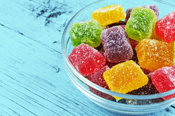 Fruit jellies on a plate on a blue wooden background