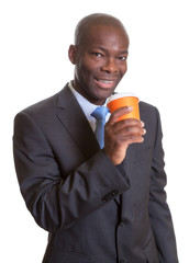 Afrikanischer Geschäftsmann im dunklen Anzug macht eine Kaffeepause