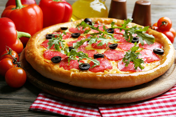 Tasty pizza with salami on decorated wooden table, close up