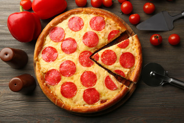 Hot tasty pizza with salami on wooden background, close up