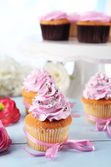 Tasty cupcakes on tray, on light background