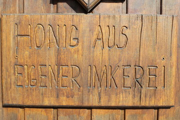 Geschnitzte Holztafel: "Honig aus eigener Imkerei"