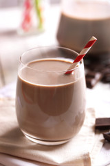 Glass of chocolate milk on table close-up