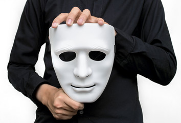 Man wearing black shirt holding a white mask with white background.