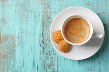Cup of coffee on color wooden background