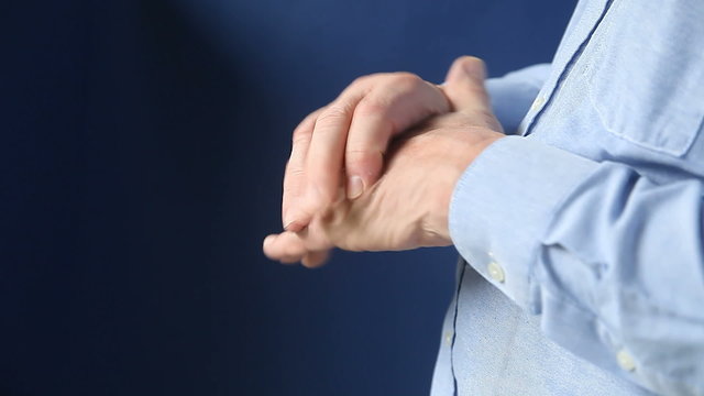 Businessman could be experiencing numbness, soreness or stiffness in his hand.