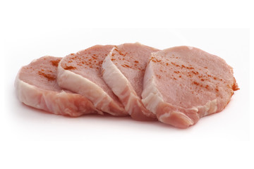 four pieces of raw pork on a white background