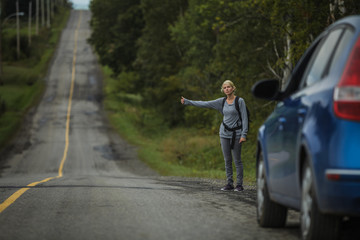 Blonde Woman Hitchhiking on the Side of the Road