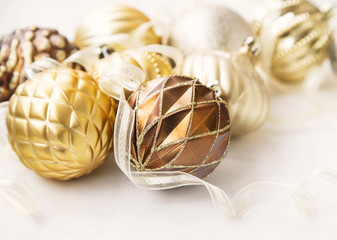 Fototapeta na wymiar Golden Christmas tree ornaments with delicate balls and ribbon