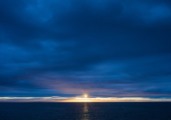 Sunset over Ocean on a Dark Cloudy Evening