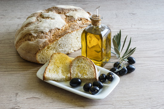 Bodeg&oacute;n con hogaza de pan y aceite de oliva virgen extra