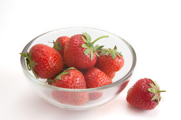 strawberries in a glass bowl on a white background