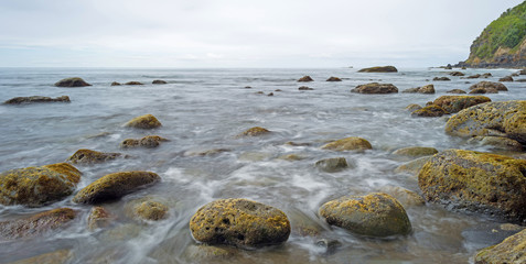 Slow waves on a rocky beach in summer