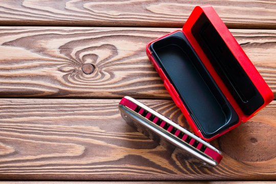 harmonica next to the packaging on the wooden background