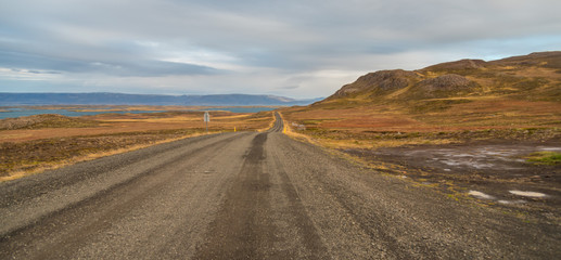 Highway through South Icelandic landscape under cloudy sky
