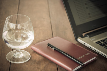 glass of water blown organizer or notebook and pen and the laptop