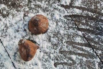 Two chocolate truffles on the wooden background