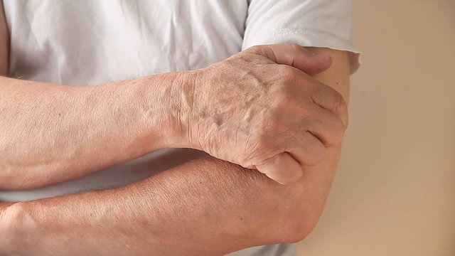 A man scratches a persistent itch on his arm.